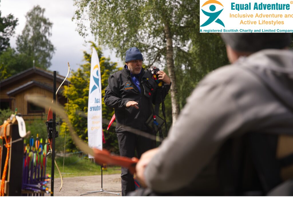 Two people take part in archery, one is in a wheelchair, the other is standing. The logo in the top right reads, equal adventure, inclusive adventure and active lifestyles.